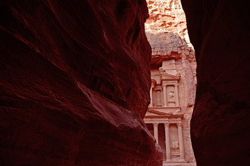 A visit to Petra starts with passing some ancient monuments before walking into the Siq, a narrow canyon that hardly lets in any sunlight and which opens up at the end to the Treasury (Al-Khazneh). 
