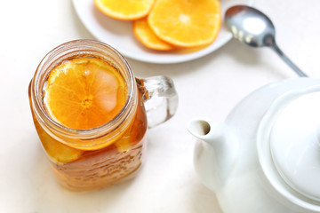 Pomarańczowa herbata. Szklanka czarnej herbaty z plastrami pomarańczy - obrazy, fototapety, plakaty