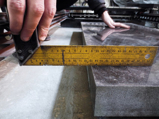 The person measures the angle with a setsquare