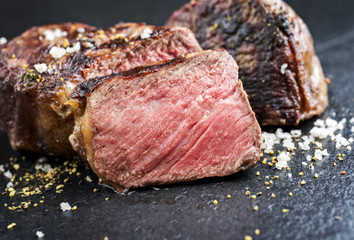 Traditional barbecue wagyu roast beef sliced as top view on a black board