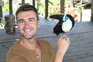 Man holding a colourful toucan bird  © ajr_images