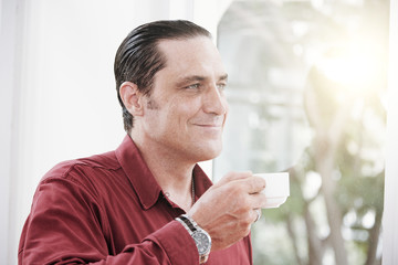 Satisfied businessman enjoying cup of coffee during coffee break