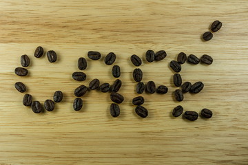 Laid out coffee beans text on wood background