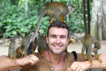 Fototapeta premium Handsome man with titi monkey's group 