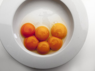 Varias yemas de huevo sobre un plato redondo blanco
