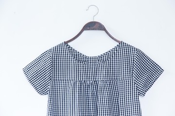 Small scotch colour blouse is clothes hanger on white background.