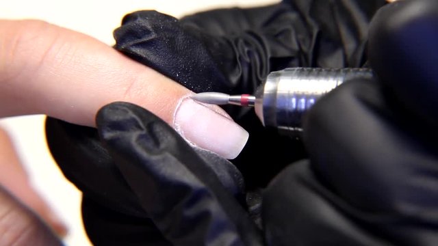 Closeup macro of removing nail cuticles and fingernail polishing using nail milling machine fraser