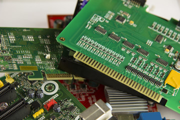 Green printed circuit boards lie in a pile on the table background