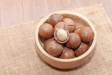 close up of organic macadamia nut on wooden bowl
