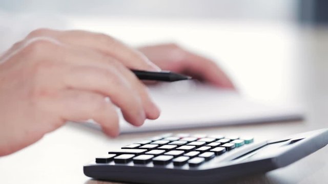 Man doing soma calculations on calculator