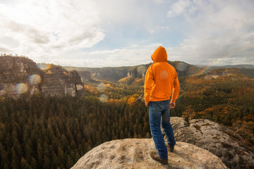 Mann steht auf den Berggipfel und genießt den Aussicht