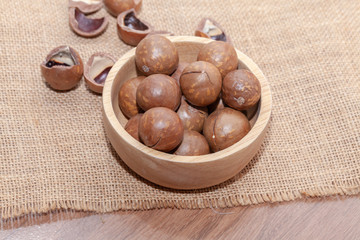 close up of organic macadamia nut on wooden bowl