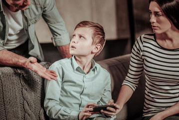 Do not bother me. Emotional kid turning head while listening to his father