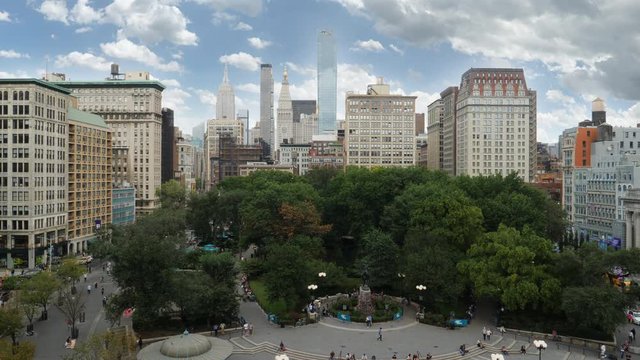A high angle daytime establishing shot of Union Square Park with the Manhattan skyline in the distance.  	