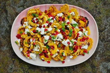 Roasted delicata squash salad with goat cheese and pomegranate in the fall