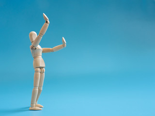 Wooden puppet lift hands on the air for lets something in the air. Legs of standing wooden puppets.