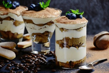 Classic Tiramisu dessert in a glass isolated on dark background