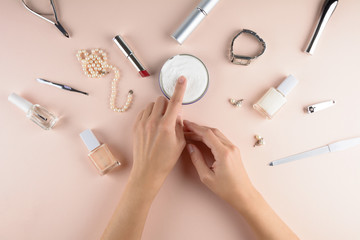 Skin care concept. Woman applying hand cream on puffy background. Flat lay. Top view