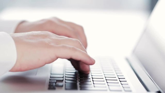 close up shoot of male hands typing on laptop keyboard