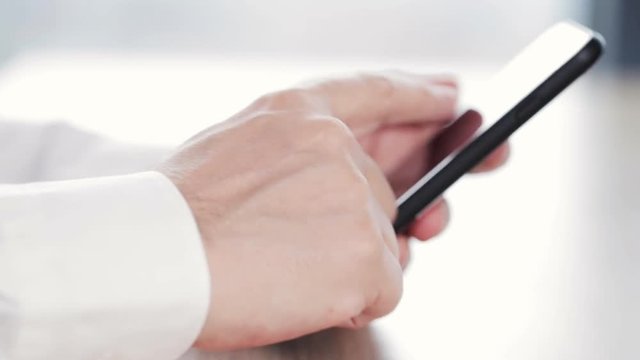 man using his smartphone on desk