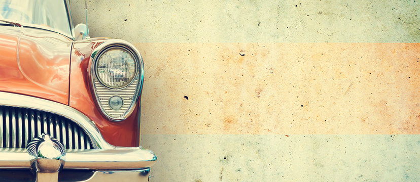 The headlight of the old beautiful car on the background of a concrete wall. Copy space. Concept banners repair, sale of cars.