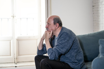 Sad unhappy old senior man suffering from memory loss and alzheimer feeling depressed and lonely