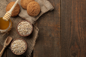Dry oatmeal, honey and oatmeal cookies. food. healthy food. on a brown wooden table. top view with space for inscription