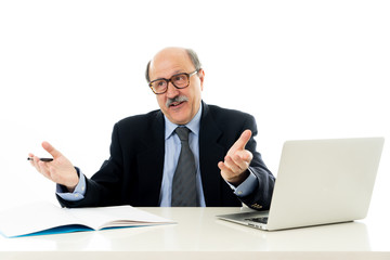 Pleased mature business man in his 60s working on laptop confident of success