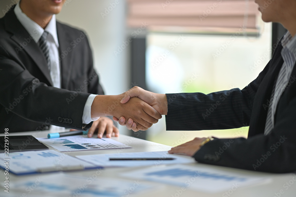 Wall mural cropped shot of two businessmen shaking hands in meeting room