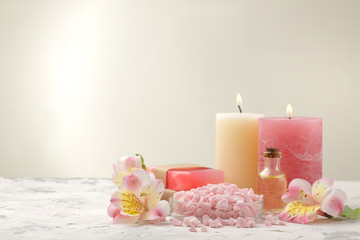 Spa composition with sea salt, aroma oils and handmade soap with flowers. spa concept. on a light background. with space for inscription