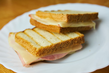 Tasty ham and cheese toast on white plate