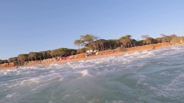 Shooting from sea, sunset and waves cover camera. Portugal Algarve.