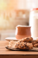 Homemade biscuits with chocolate chips on slatted table front vertical
