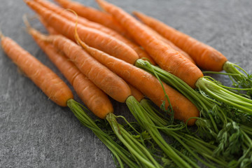 healthy eating, food, dieting and vegetarian concept - close up of carrot bunch on table
