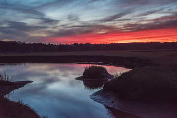 Dramatic red sunset on the river. Dark mystical photo.
