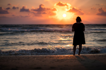 Woman in the beach, sunset silhouette