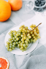 Summer picnic in nature, beautiful fruits and wine. Pomegranate, apples, pastries and bread on a blanket. Cheese and cherries in a beautiful design on the table
