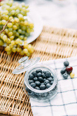 Summer picnic in nature, beautiful fruits and wine. Pomegranate, apples, pastries and bread on a blanket. Cheese and cherries in a beautiful design on the table