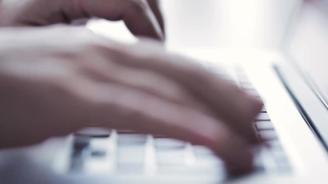 Man typing on laptop keyboard