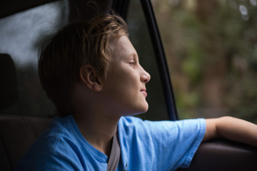 Portrait of a boy riding in a car with the window open.