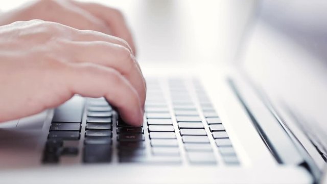 Man working on laptop, writing an email, report, complaint etc
