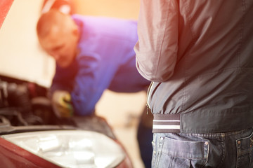 mechanic watching a car with an open hood