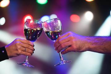 Cheerful couple clinking glasses of champagne at the party