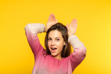 funny amusing playful girl pretending to be a bunny faking ears with her palms. teenage carefree...