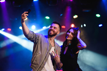 Image of happy young couple having fun at disco. Young man and woman enjoying a party.