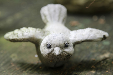 Little bird statue on wooden table.