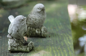 Little bird statue on wooden table.