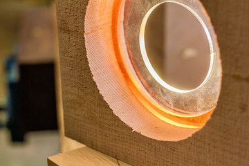 Wood and light, Eco-friendly woodworker's shop. Details and focus on the texture of the material, sawdust, and hands or lighting, while making a futuristic lamp. Mastering wood with peacefullness.