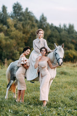 Wedding in American style, on a ranch with a horse. Walk couples in the fields at sunset, with...