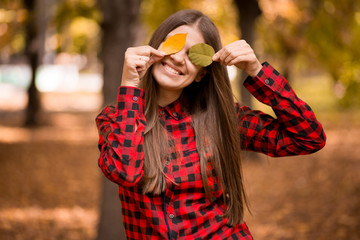 Portrait of cheerful young woman with in autumn park